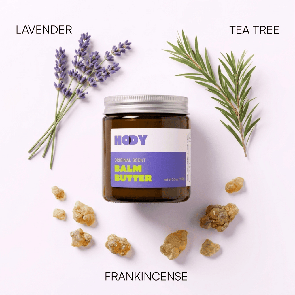 Jar of HODY Original Scent Balm Butter surrounded by its scent ingredients: lavender, tea tree and frankincense resin